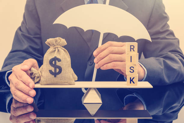 financiële risico-evaluatie / portefeuille risk management en bescherming concept: zakenman heeft een witte paraplu, een dollar zak op fundamentele evenwicht schaal beschermt, verdedigt geld cheat of fraude - risk stockfoto's en -beelden