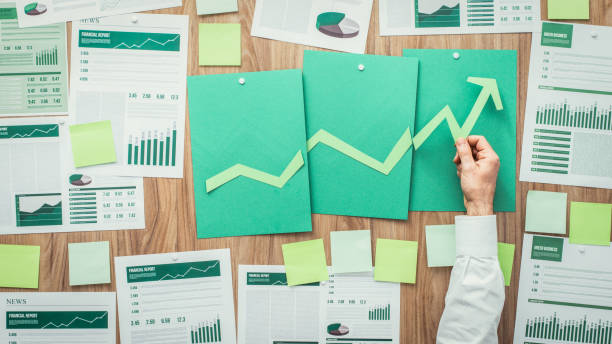 Financial success and green business Businessman composing a successful financial chart with arrow going up, he is using green paper cuts, eco business and financial success concept report document stock pictures, royalty-free photos & images