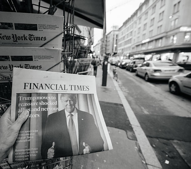 Financial Times about Donald Trump new USA president Paris, France - November 10, 2016: Man buying Financial Times newspaper with shocking headline title at press kiosk about the US President Elections - Donald Trump is the 45th President of United States of America donald trump stock pictures, royalty-free photos & images