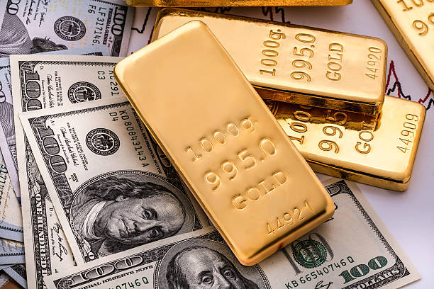 Fine gold bars and bullion Gold bullions on hundred dollars banknotes and chart background dollar  stock pictures, royalty-free photos & images