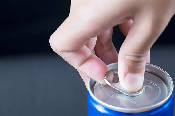 Finger opening a blue can, isolated on black background stock photo