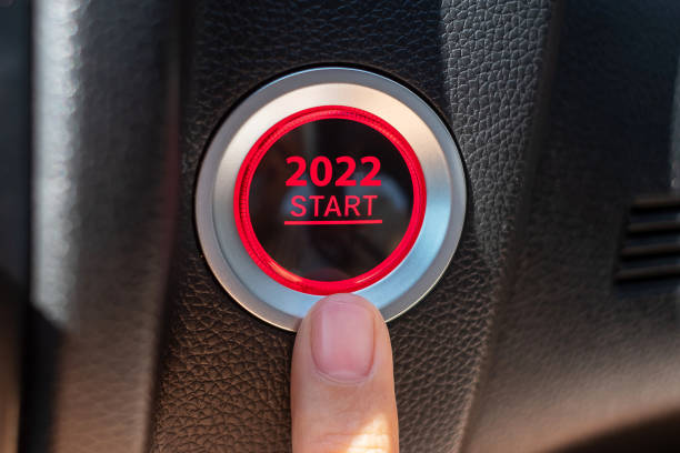 Finger press a car ignition button with 2022 START text inside modern electric automobile. New Year New You, resolution, change, goal, vision, innovation and planning concept stock photo