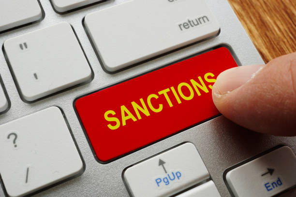 doigt appuie sur les sanctions de bouton. - guerre économique photos et images de collection