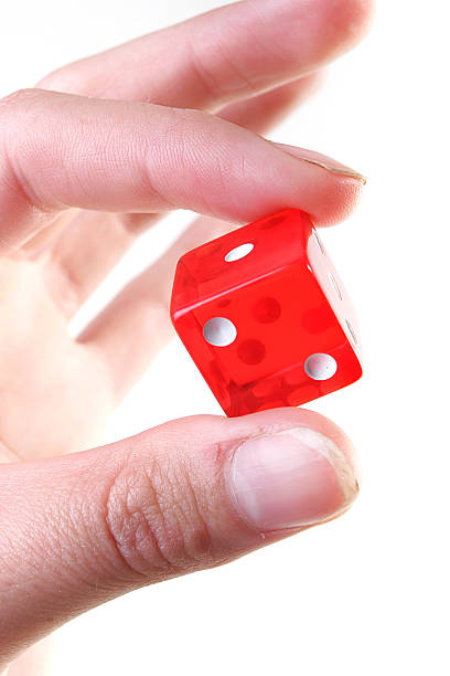 Fingers holding red Dice stock photo