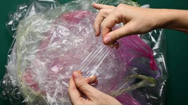 Fingers pulling used plastic bags ready to recycling stock photo
