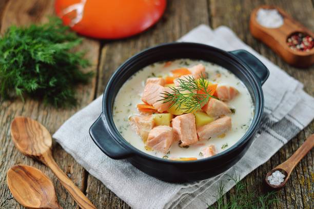 Finnish wild salmon soup with cream on an old wooden background. Rustic style. stock photo