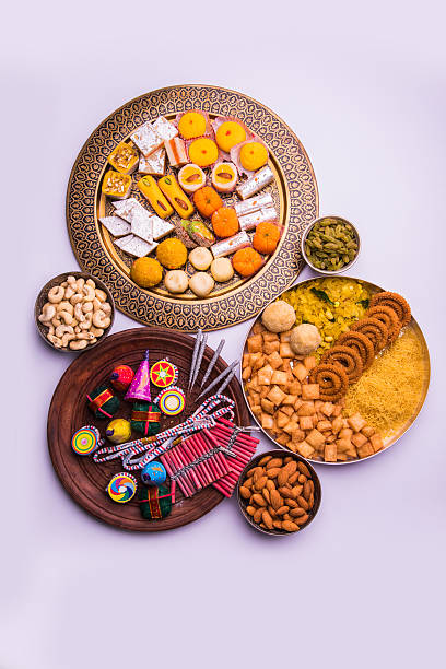 fire crackers and sweet food in diwali festival indian sweet food and fire crackers served in plate showing diwali concept mithai stock pictures, royalty-free photos & images