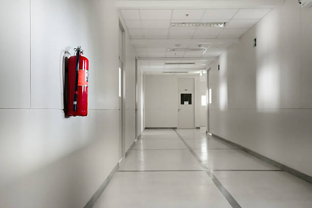 Fire extinguisher in empty white corridor stock photo