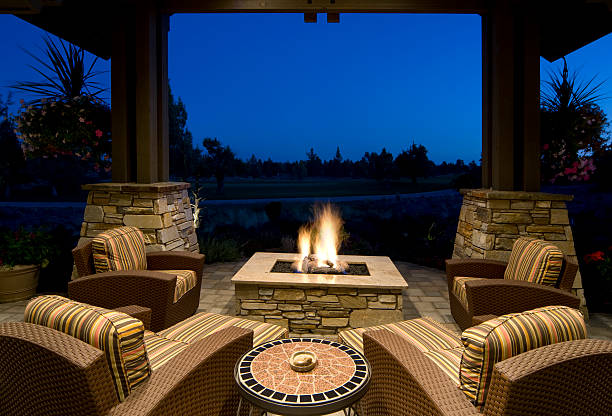 Fire Pit Deck at Night Deck with fire pit, outdoor furniture, and with a beautiful evening setting. fire pit stock pictures, royalty-free photos & images