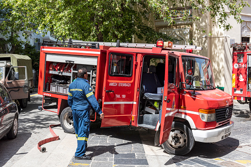 Rhodes, Greece - May 27, 2022: Fire truck and fireman man in the street in the old town of Rhodes island, Greece.