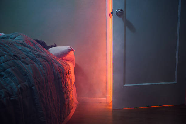 fire visible through bedroom door - smoke alarm stockfoto's en -beelden