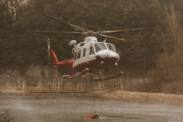 de helikopter die van de brandweer water van een rivier neemt - save water bucket stockfoto's en -beelden
