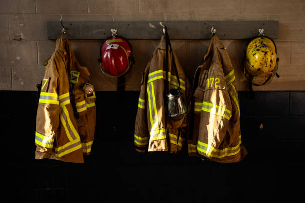 Firefighter protection clothes firefighter protection clothe and respiratory mask hanging on the fire station wall firefighters stock pictures, royalty-free photos & images