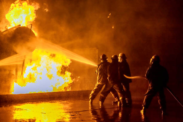 bomberos extinguiendo un incendio industrial - firefighters fotografías e imágenes de stock