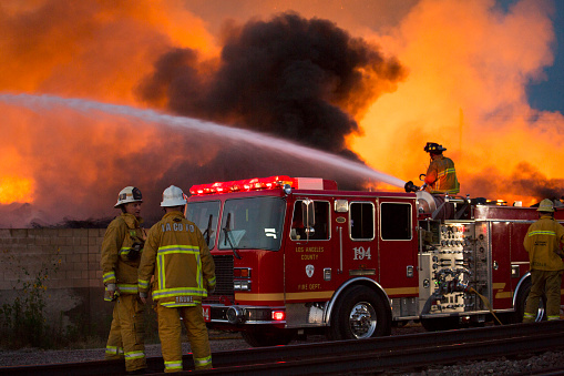 Santa Fe Springs, California - May 29, 2014: Firefighters try to douse the flames of a recycling sorting facility on fire.