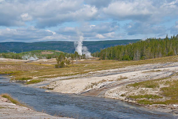 Firehole River The Firehole River is one of the two major tributaries of the Madison River. Its source is Madison Lake on the Continental Divide. The river and one of many geysers were photographed from the Old Faithful area in Yellowstone National Park, Wyoming, USA. jeff goulden yellowstone national park stock pictures, royalty-free photos & images
