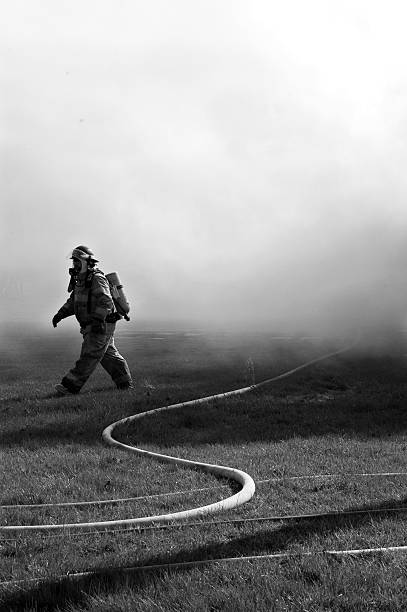Fireman Walking Amidst Smoke stock photo