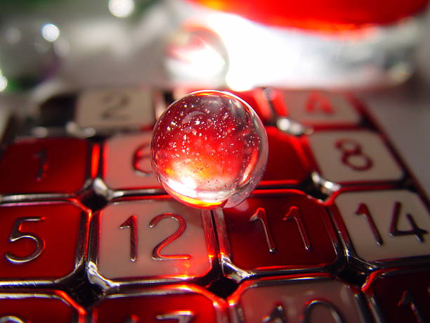 firemarble A wet marble sitting on a number puzzle, lit by a flashlight behind a glass of cranberry juice. I was playing around with photographing "things i can reach from the couch" and was astonished that this was the result. numerology stock pictures, royalty-free photos & images