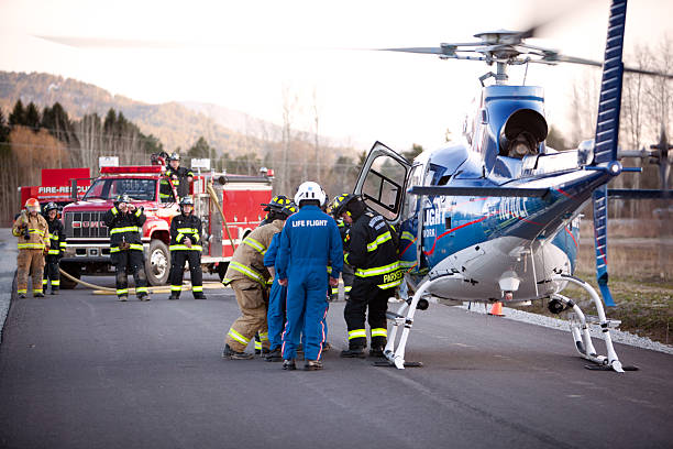Firemen load a gurney into waiting helicopter stock photo
