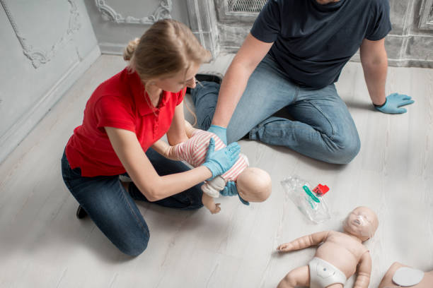 First aid training Instructor showing how to safe a life when the baby is choked sitting during the first aid group training indoors choking photos stock pictures, royalty-free photos & images