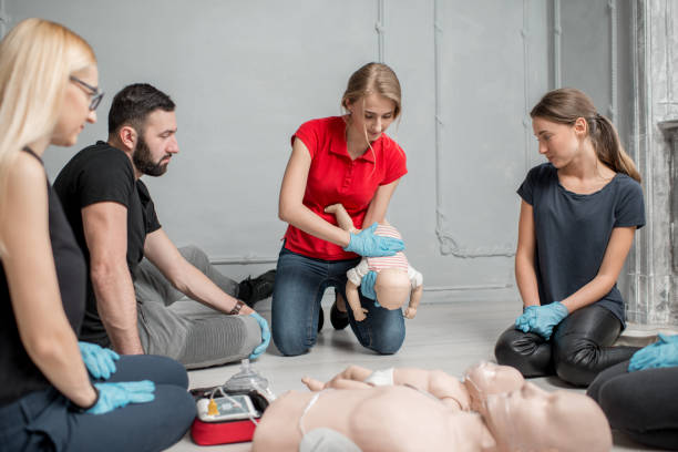 First aid training Instructor showing how to safe a life when the baby is choked sitting during the first aid group training indoors choking photos stock pictures, royalty-free photos & images