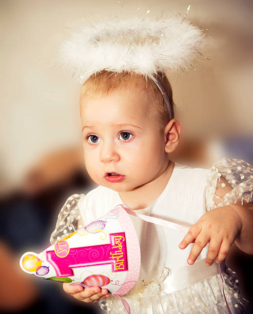 First Birthday Of Little Angel Portrait of little cute girl holding 1st birthday cardboard angel number stock pictures, royalty-free photos & images