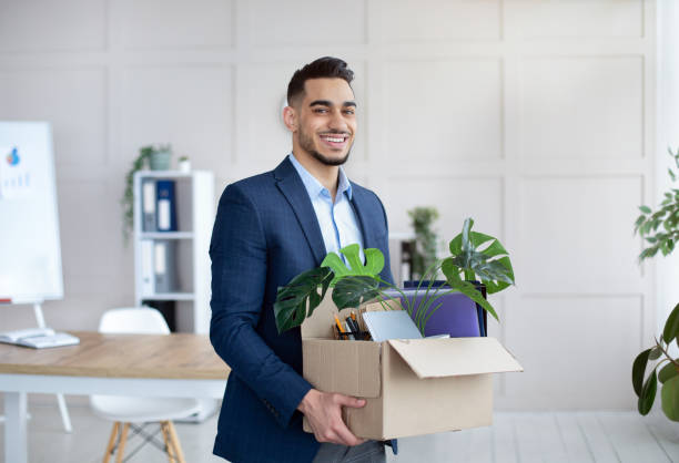 First day at office. Portrait of confident Arab businessman with belongings moving to new office First day at office. Portrait of confident Arab businessman with belongings moving to new office. Happy young male manager holding box with supplies, changing working place, indoors quitting a job photos stock pictures, royalty-free photos & images