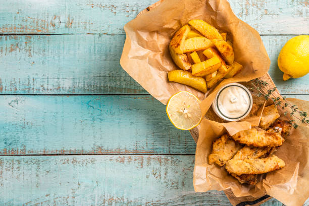Fish and chips on blue wooden table, British traditional food. Fish and chips on blue wooden table, British traditional food. fried stock pictures, royalty-free photos & images