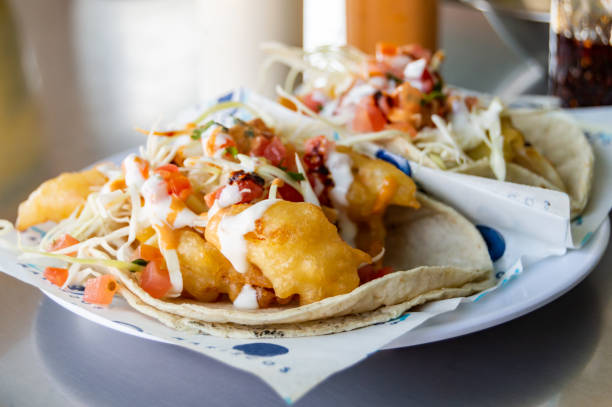 Fish and shrimp tacos, Baja California style seafood tacos Fish and shrimp tacos, Baja California style seafood tacos served with cabbage,tomatoes,cilantro and a variety of salsas fish fry stock pictures, royalty-free photos & images
