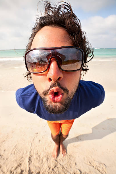 Fish eye - Young man blowing a kiss Extreme close up (fisk eye) of a young man blowing a kiss fish eye lens stock pictures, royalty-free photos & images