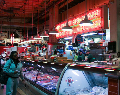 Philadelphia, Pennsylvania, USA - 29 April 2022: Customers on line at a fish seafood store in the famous Reading Market in Philadelphia Pennsylvania.