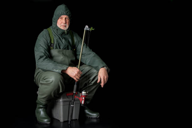 A fisherman in waders and raincoat. stock photo