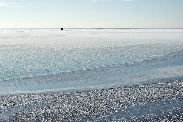 Fishermen on the iced sea. Winter sea. stock photo