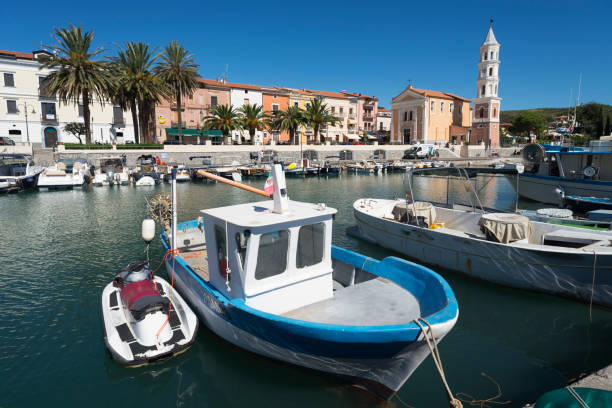 Fishing and motor boats in the picturesque harbor of Scario on the coast of the Mediterranean Sea in Cilento, Campania, Italy stock photo