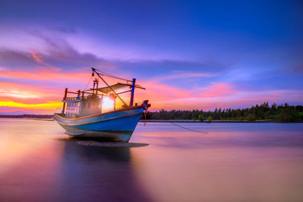 Fishing boat in tropical beach with beautiful sunset time. Fishing boat in tropical beach with beautiful sunset time. capsizing stock pictures, royalty-free photos & images