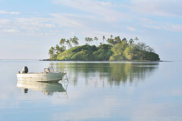 рыбацкая лодка швартовки над спокойными водами на мури лагуны rarotonga острова кука - cook islands стоковые фото и изображения