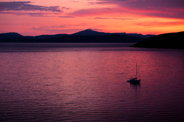 fishing boat on the sea at sunset at Skye stock photo
