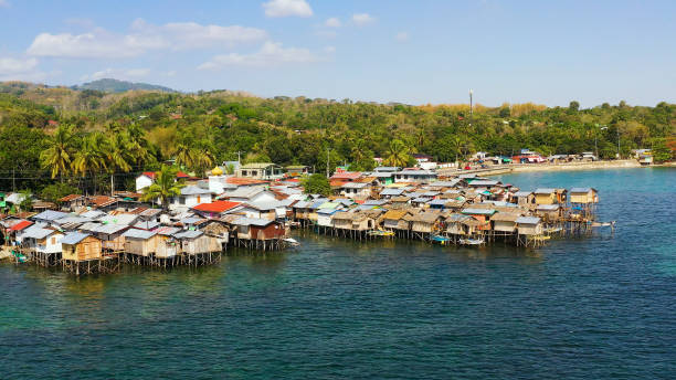 Fishing village in the Philippines. Mindanao Village of fishermen with houses on the water, with fishing boats. Fishing village with wooden houses on stilts in the sea. Philippines, Mindanao. fishing village stock pictures, royalty-free photos & images