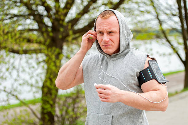 Fit man jogger listening music by earphones. stock photo