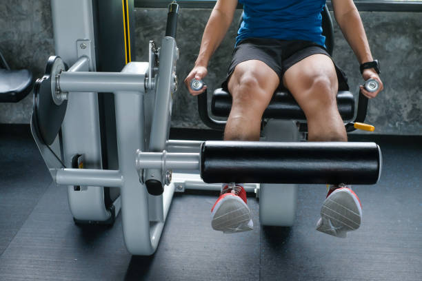 Fit man training legs on leg press machine in the gym stock photo