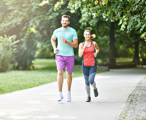 fitness woman park exercise lifestyle outdoor sport healthy couple nature active young fit training athlete stock photo