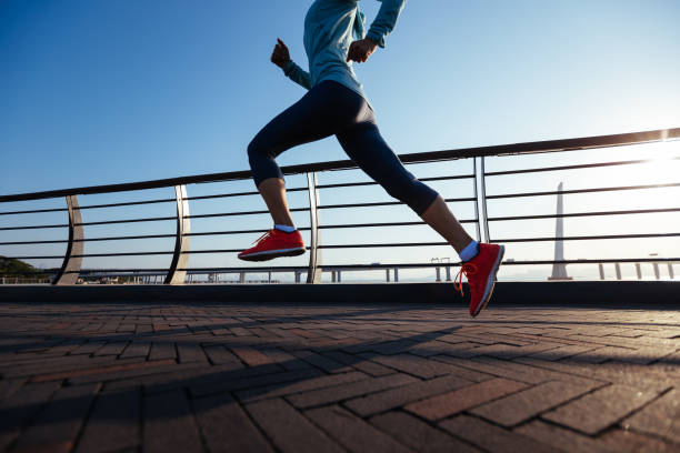 Fitness woman runner running on seaside bridge stock photo