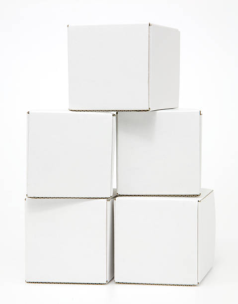 Five blank white cardboard cartons casually stacked stock photo