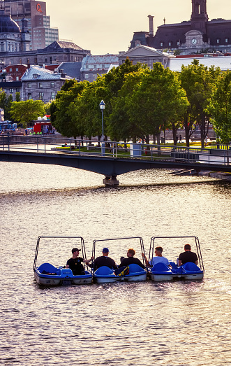 June, 2018 - Montreal, Canada: Five men are having fun on pedal boards on the river at the old port downtown in Montreal, Quebec, Canada.