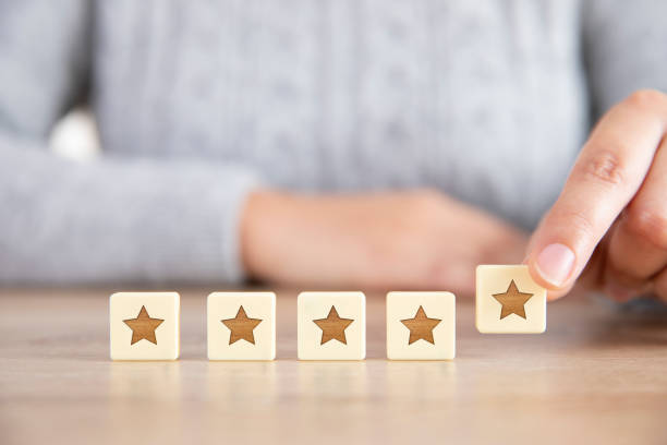 Five Stars Rating and Positive Feedback Concept with Woman Customer experience concept. A latin woman hand putting wooden five star shape and giving the best or excellent rating to business services. customer focused stock pictures, royalty-free photos & images