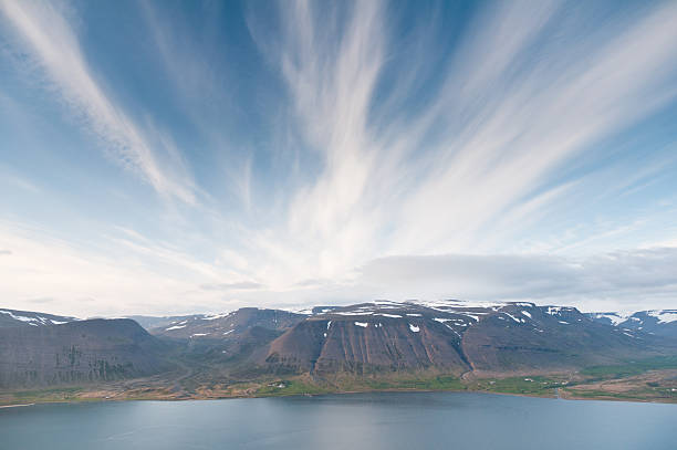 fjord surrounded by beautiful mountgains bathing in evening light stock photo