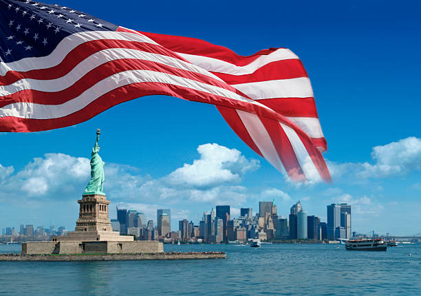 US flag and Statue of Liberty with New York behind stock photo