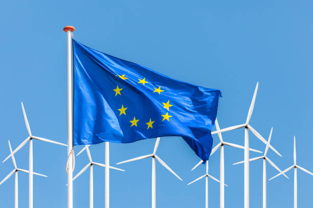 Flag of the European Union in front of a large windpark with wind turbines stock photo