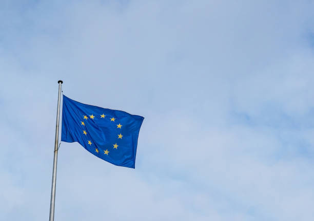 Flag of the European Union waving in the wind with a blue sky stock photo