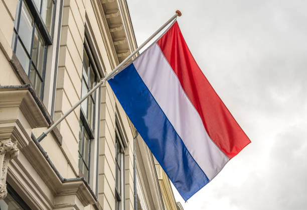 flagge der niederlande winkend im wind in der stadt utrecht - holländische flagge stock-fotos und bilder
